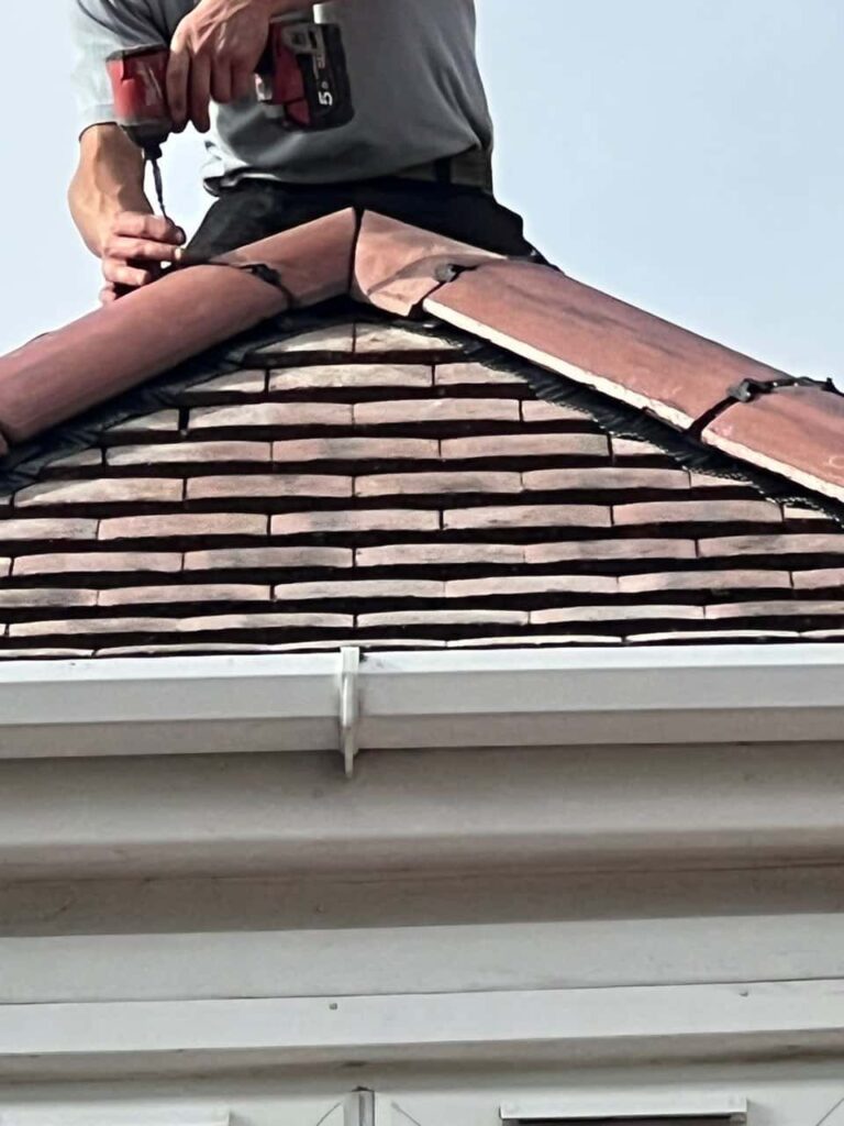 This is a photo of one of the operatives of Belper Roofing Repairs installing new ridge tiles