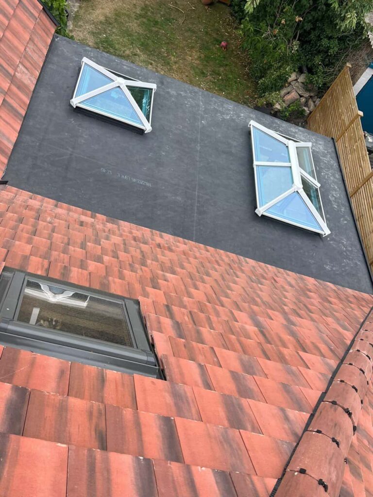 This is a photo taken from the roof ridge looking down a tiled pitched roof on to a flat roof. Works carried out by Belper Roofing Repairs